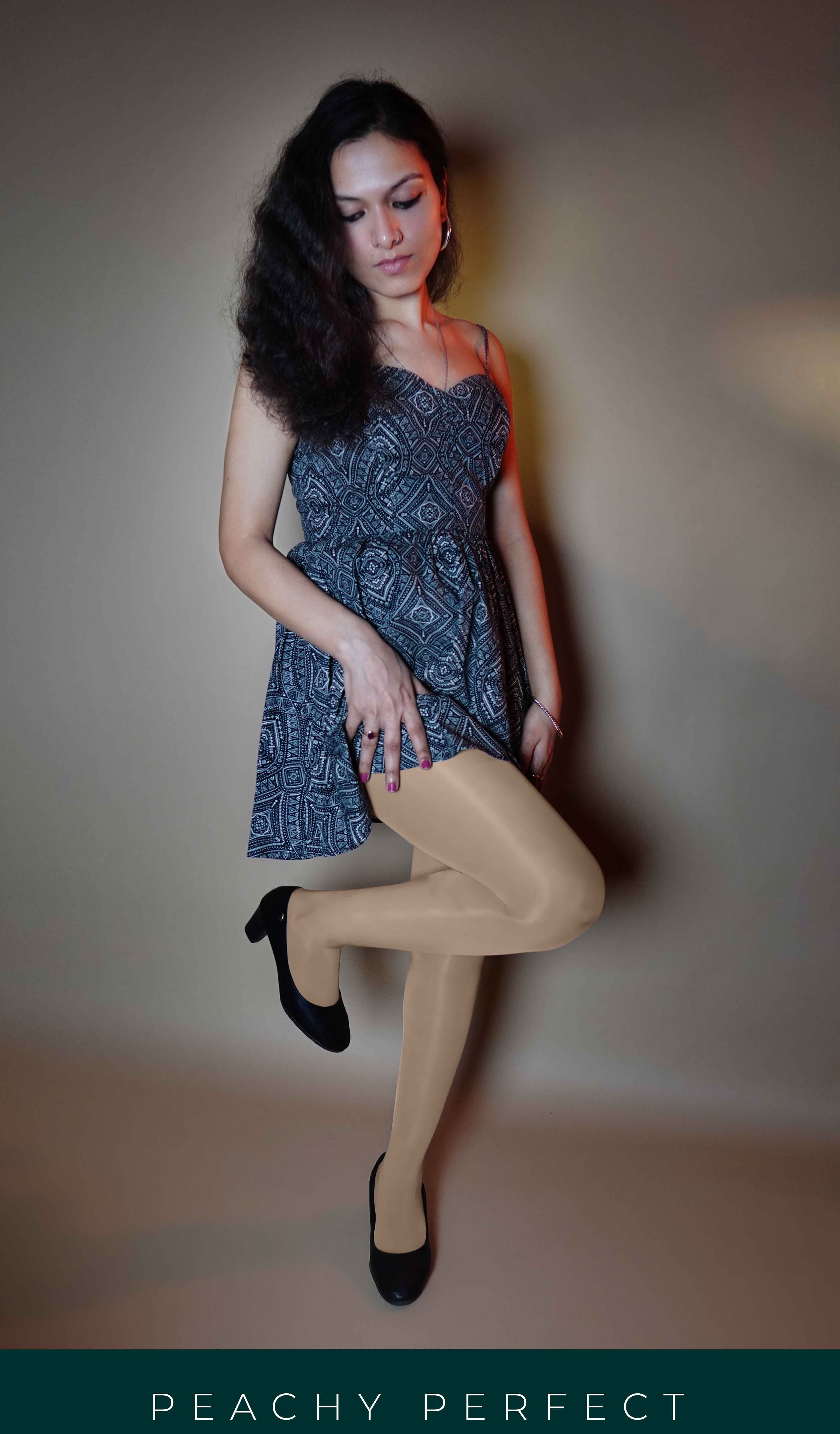 A model posing with her leg bent forward and her hand on her thigh, wearing silken touch plus size sheer stockings, showcasing the no tear smooth look-Muselot