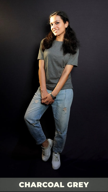 A stylish model with a smile on her face wearing long length t shirt pairing with ripped jeans and white shoes and a silver watch around her wrist, highlighting the comfy and casual outfit-Muselot