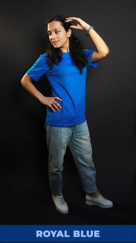 A woman wearing a unisex plain cotton round neck royal blue t-shirt, posing with her hand on her head and another on her waist as she looks sideways, highlighting a summer casual fit-Muselot