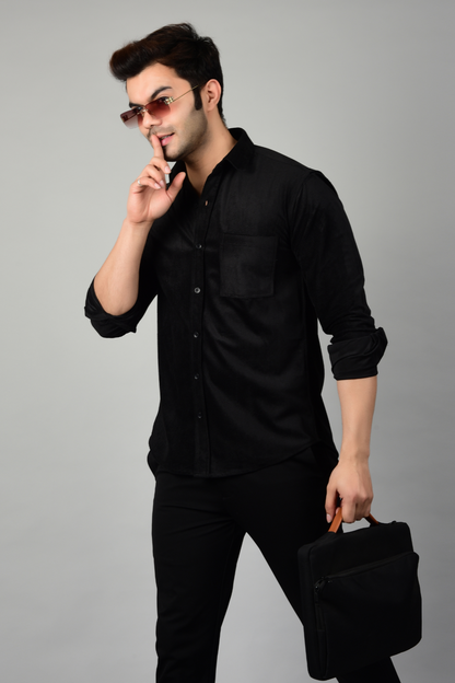 Man wearing a stylish black shirt and black pants, holding a black briefcase, showcasing a sleek and sophisticated look-Muselot