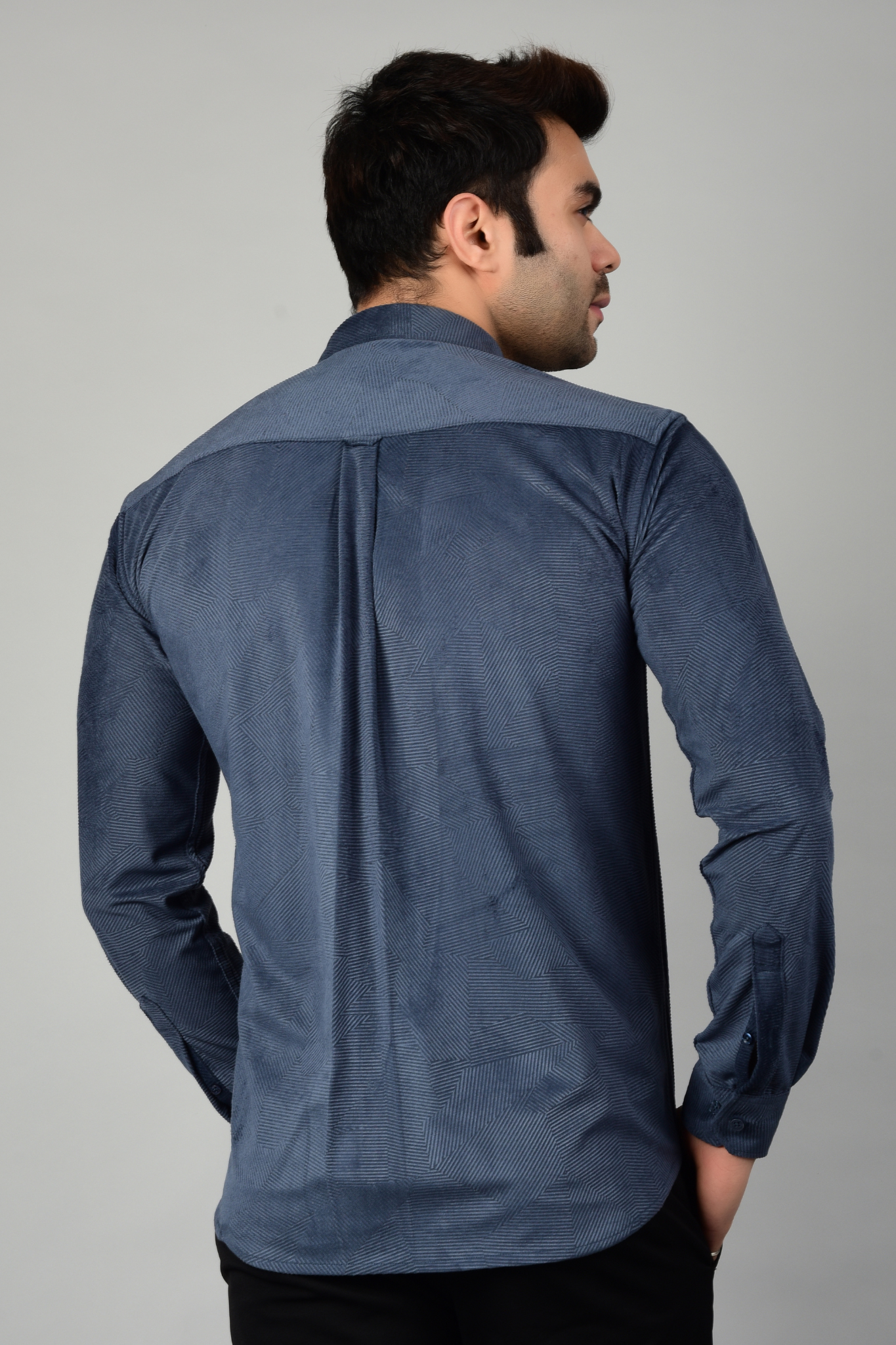 Man wearing a stylish blue patterned shirt, photographed from the back, showcasing the detailed texture and design of the shirt, highlighting its modern and sophisticated appeal-Muselot