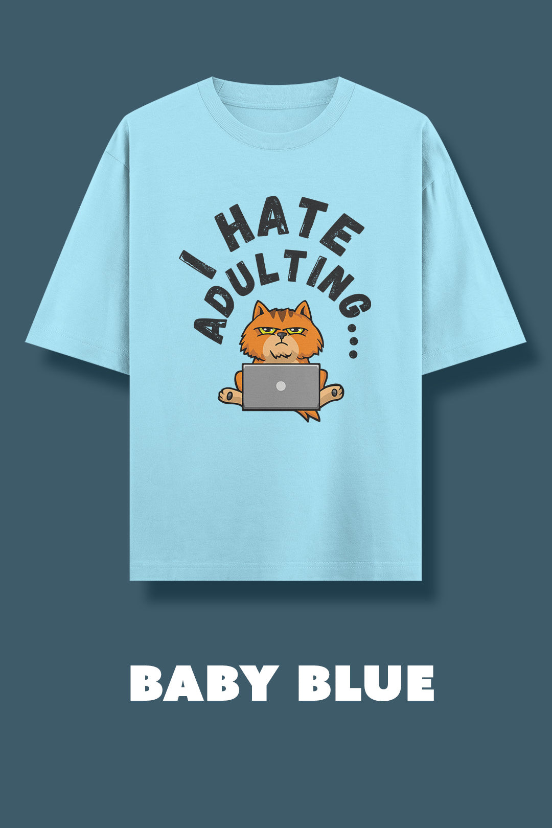 Baby blue oversized t-shirt showcasing a bold “I Hate Adulting” graphic, highlighting the grumpy orange cat illustration with a laptop for a fun, relatable statement design — Muselot.