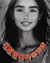 a model wearing the Bandhani handmade necklace, with intricate designs and vibrant hues that enhance the traditional charm and sophisticated appeal of the piece — Muselot.