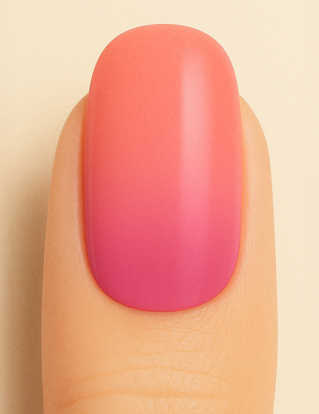 A close-up shot of a model’s finger wearing Berry Bliss Ombre nail stickies, showcasing a smooth gradient that transitions from a bright coral-pink top to a deeper berry hue at the base, highlighting the playful blend of warm tones with a glossy salon-like finish – Muselot.