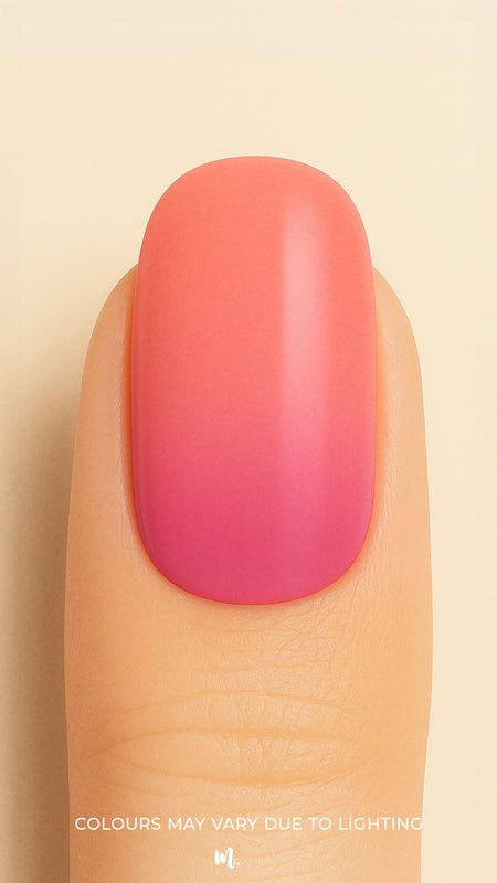 A close-up shot of a model’s finger wearing Berry Bliss Ombre nail stickies, showcasing a smooth gradient that transitions from a bright coral-pink top to a deeper berry hue at the base, highlighting the playful blend of warm tones with a glossy salon-like finish – Muselot.