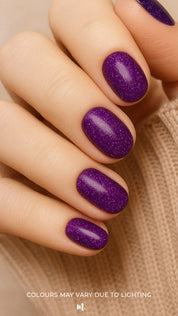 A model hand styled with Berry Cosmos Glitter nail stickies, showcasing a deep purple base lit up with tiny pink, blue, and violet sparkles. The look highlights the galaxy-like shine and bold elegance of this cosmic-inspired glitter manicure – Muselot.
