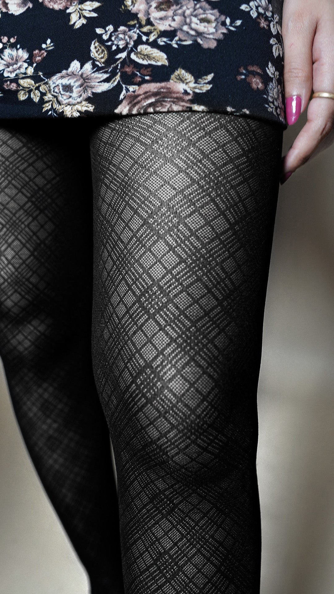 A close-up image of the leg of a model wearing patterned stockings for women, highlighting the modern checkered texture-Muselot