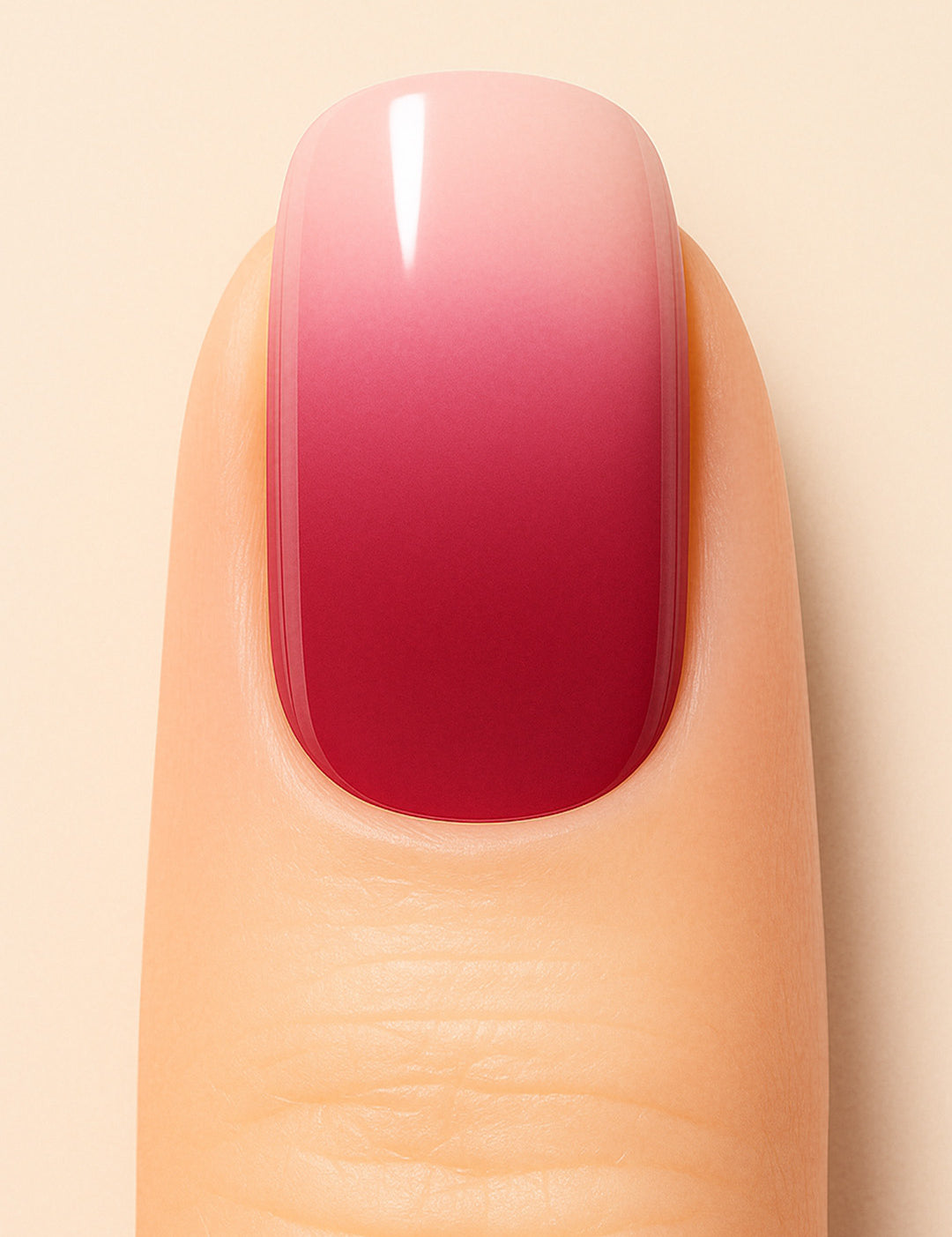 A close-up shot of a model’s finger wearing Blush Mist Ombre Nail Stickies, showcasing a smooth gradient that blends soft blush pink into a deep misty red, creating a chic and glossy ombre manicure finish – Muselot.
