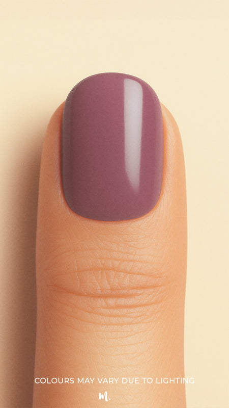 A close-up shot of a model’s thumb wearing Blushed Mauve nail stickies, showcasing the soft mauve shade with a smooth glossy solid finish, highlighting the elegance of minimal nail art in a refined and classy look – Muselot.
