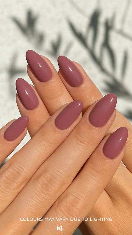 A shot of a model’s hand wearing Blushed Mauve nail stickies, showcasing the soft mauve shade in a glossy solid finish, highlighting the simplicity and shine of minimal nail art with a refined salon-style look – Muselot.