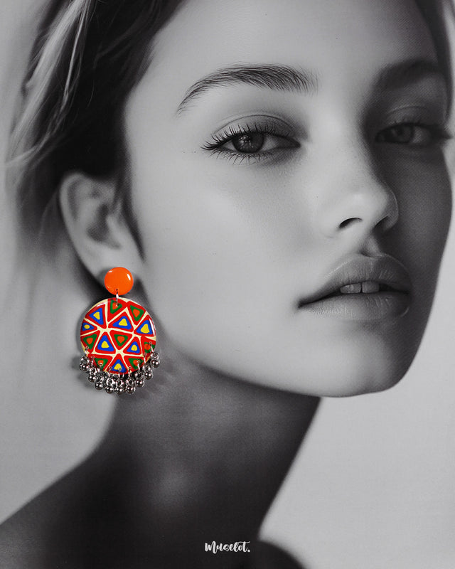 A model wearing Chakardi traditional art earrings, adorned with intricate patterns and bold designs that add a rich, cultural charm and sophisticated elegance to any look — Muselot.