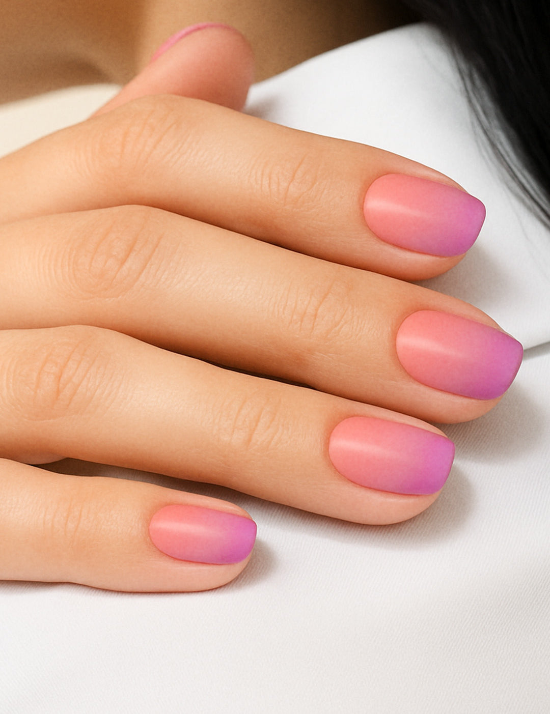 A model’s hand styled with Coral Kiss Ombre Nail Stickies, showcasing a smooth gradient blend from bright coral pink to soft lilac-purple, highlighting the glossy finish and effortless elegance of ombre nail art for a chic, salon-like look – Muselot.