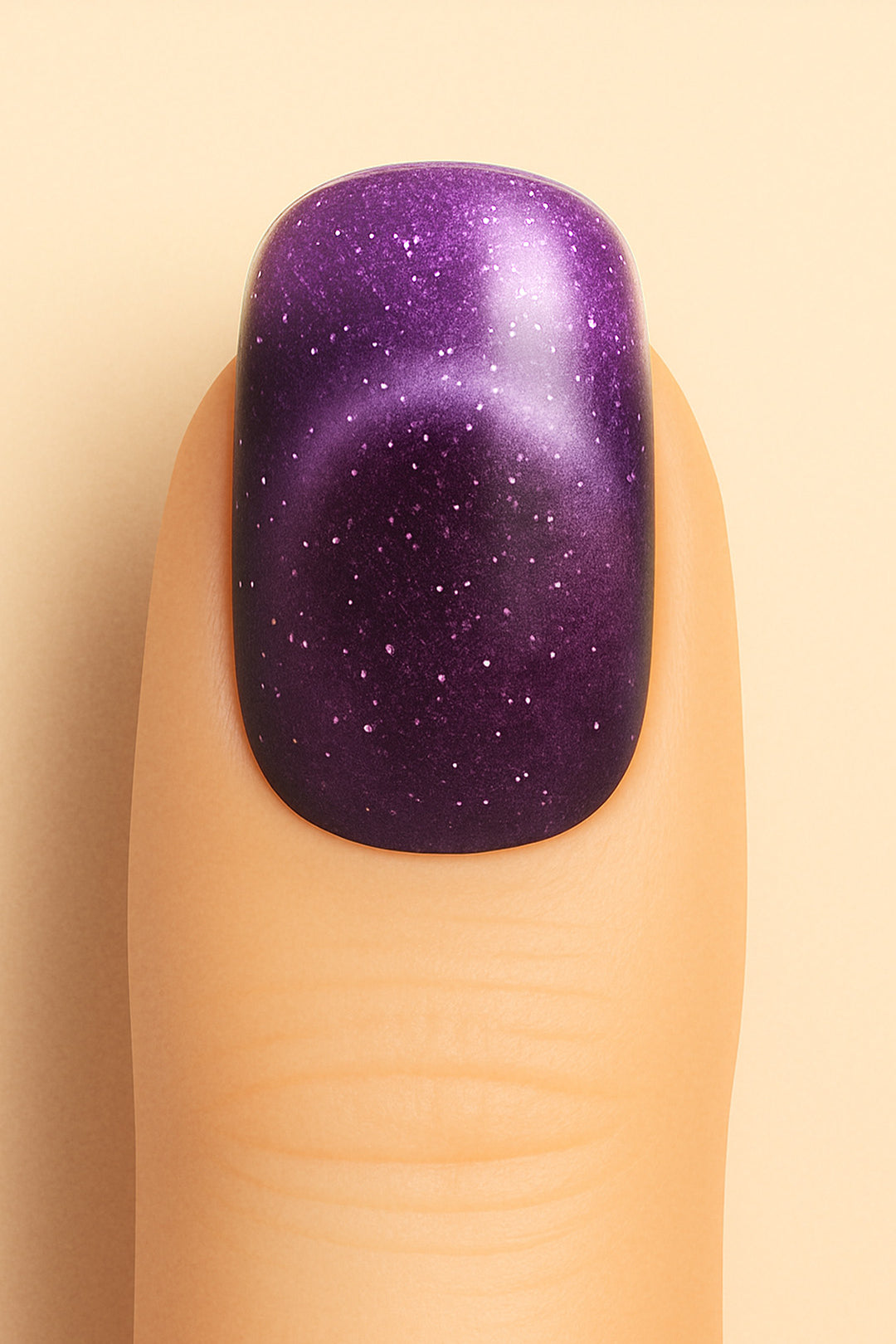 A close-up shot of a model’s finger wearing Cosmic Gaze Ombre nail stickies, showcasing a deep galaxy-purple shade that fades into subtle gradients, highlighted with tiny star-like specks for a celestial effect, emphasizing the bold and cosmic allure of ombre glitter nail art – Muselot.