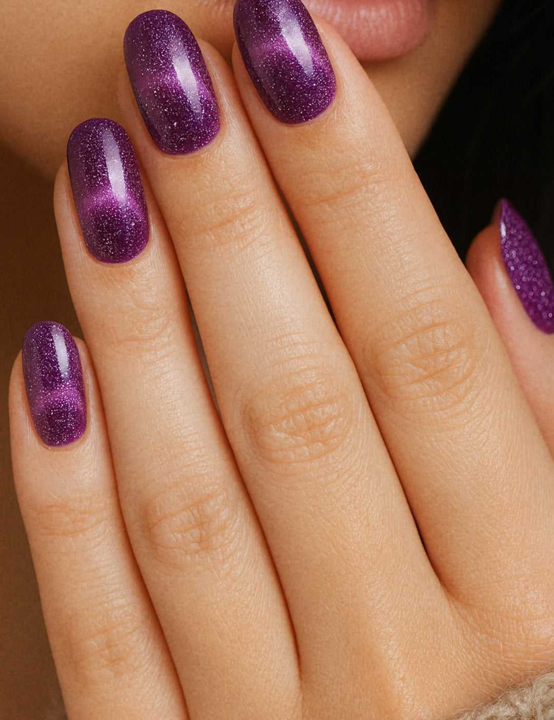 A model hand wearing Cosmic Gaze Ombre nail stickies, showcasing a deep dark-purple base that blends into a cosmic ombre effect with scattered star-like sparkles, highlighting the bold, celestial-inspired design and salon-style glossy finish – Muselot.