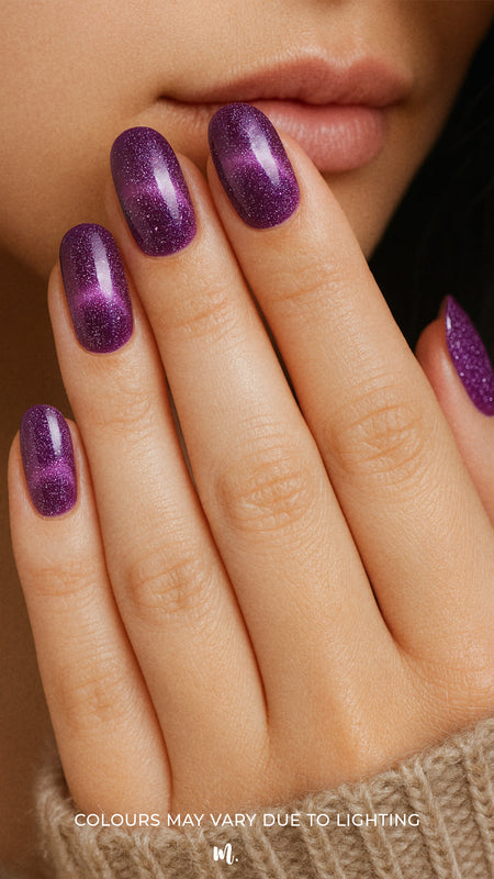 A model hand wearing Cosmic Gaze Ombre nail stickies, showcasing a deep dark-purple base that blends into a cosmic ombre effect with scattered star-like sparkles, highlighting the bold, celestial-inspired design and salon-style glossy finish – Muselot.