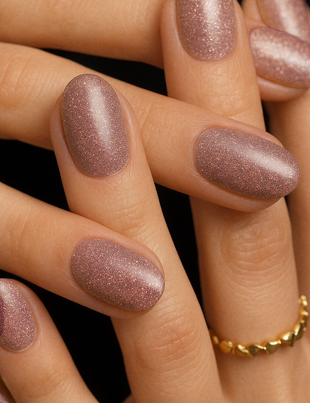 A shot of model hands wearing Dusty Rose Glitter nail stickies, showcasing the soft rose-pink shade filled with fine glitter sparkles, highlighting the shimmer and elegance of minimal nail art in a glossy salon-style finish – Muselot.