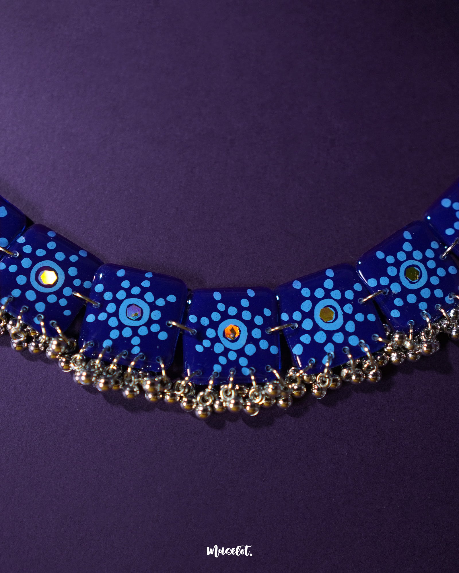 Falakzaar handcrafted necklace set styled in a natural flat lay, highlighting the vibrant blue tones and showcasing the artistic floral details and elegant thread embellishments — Muselot.