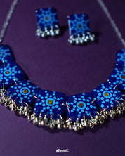 Falakzaar handmade blue necklace and earring set shown in a minimal close-up frame, highlighting the fine floral craftsmanship and showcasing the balanced fusion of color and design — Muselot.