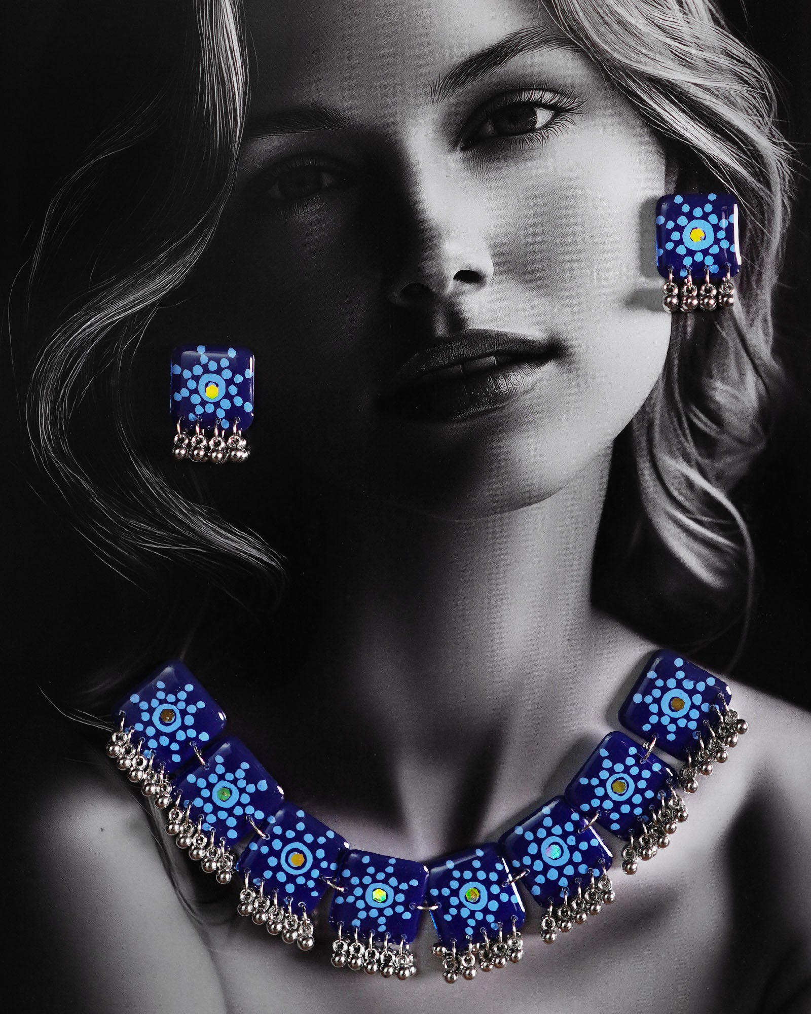 A woman wears the Falakzaar blue necklace set, showcasing the handcrafted mandala tile design and silver bead detailing that highlight the bold elegance of this statement accessory — Muselot.