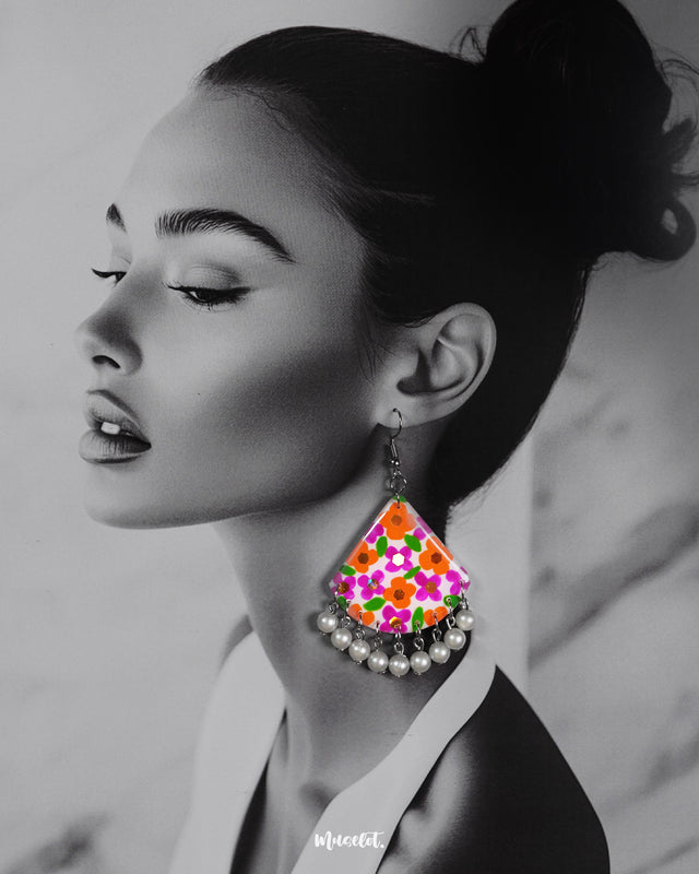 Model wearing handcrafted hook earrings with colourful floral artwork and pearl drop detailing, highlighting the artistic and ethnic flair – Muselot.