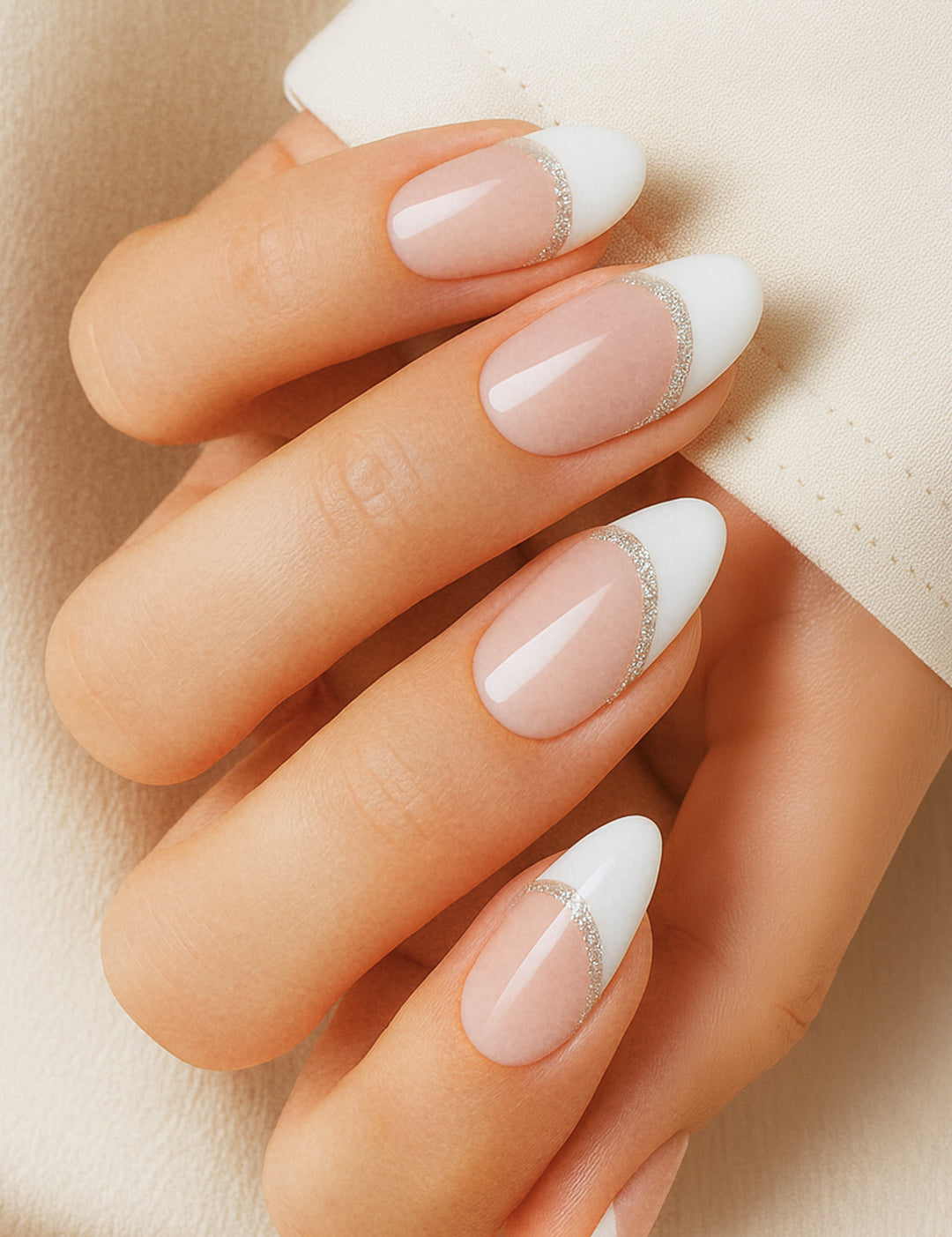 A model hand showcasing Frosted Charm French Tip Nail Stickies, featuring a soft nude base with a crisp white tip highlighted by a delicate shimmer line, capturing the timeless elegance and glossy sophistication of French manicure nail art – Muselot.