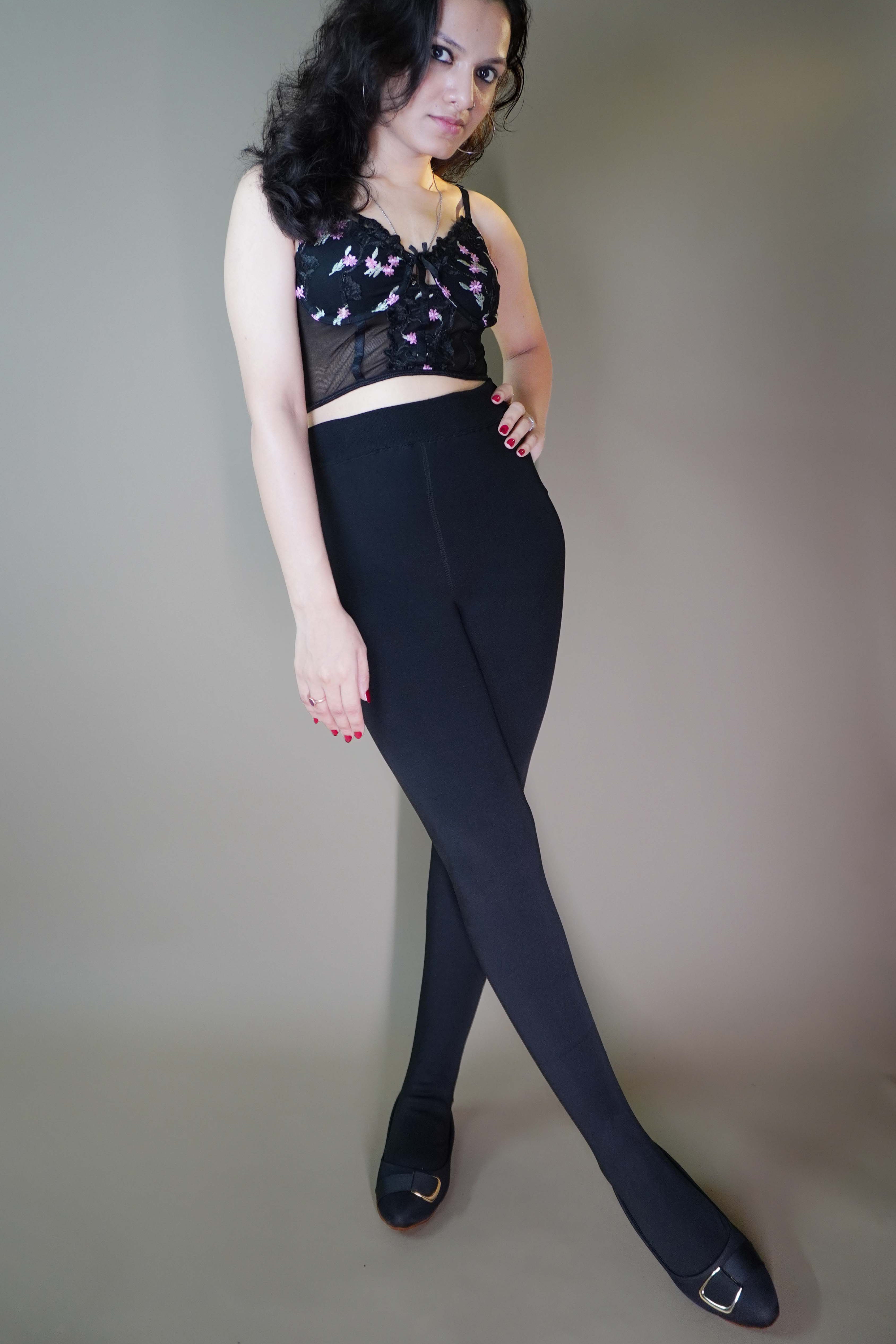 A model wearing black furry bliss tights showcasing a soft, plush texture, adding warmth and style. The tights are paired with an elegant top, enhancing the overall chic and cozy look. -Muselot