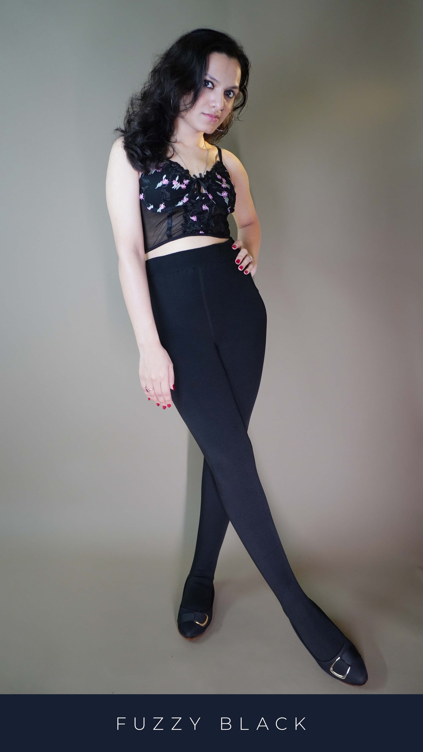 A model wearing black furry bliss tights showcasing a soft, plush texture, adding warmth and style. The tights are paired with an elegant top, enhancing the overall chic and cozy look. -Muselot