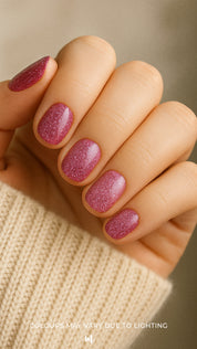 A model’s hand featuring Glitter Crush nail stickies in a pink-plum tone, finished with a sparkling glitter polish effect that adds a radiant, eye-catching glow while keeping the nails looking polished and salon-fresh – Muselot.