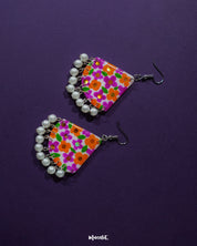 Detailed view of Guldaan floral earrings, highlighting vibrant brushwork and pearl drop embellishments against a clean backdrop – Muselot.