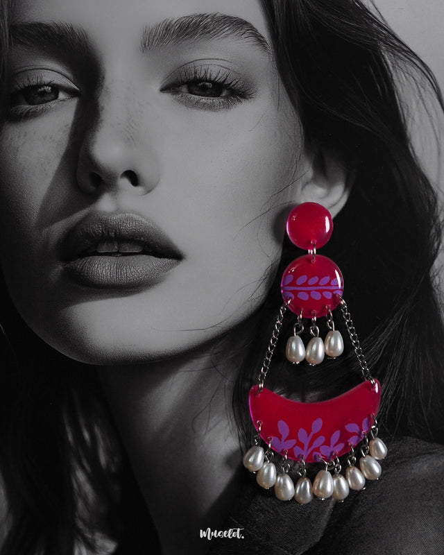 A close-up shot of a woman wearing the Gulfaam chandbali earrings showcases the intricate lilac leaf motifs on the glossy hot pink base, with soft pearl drops catching the light—blending charm and drama effortlessly — Muselot.