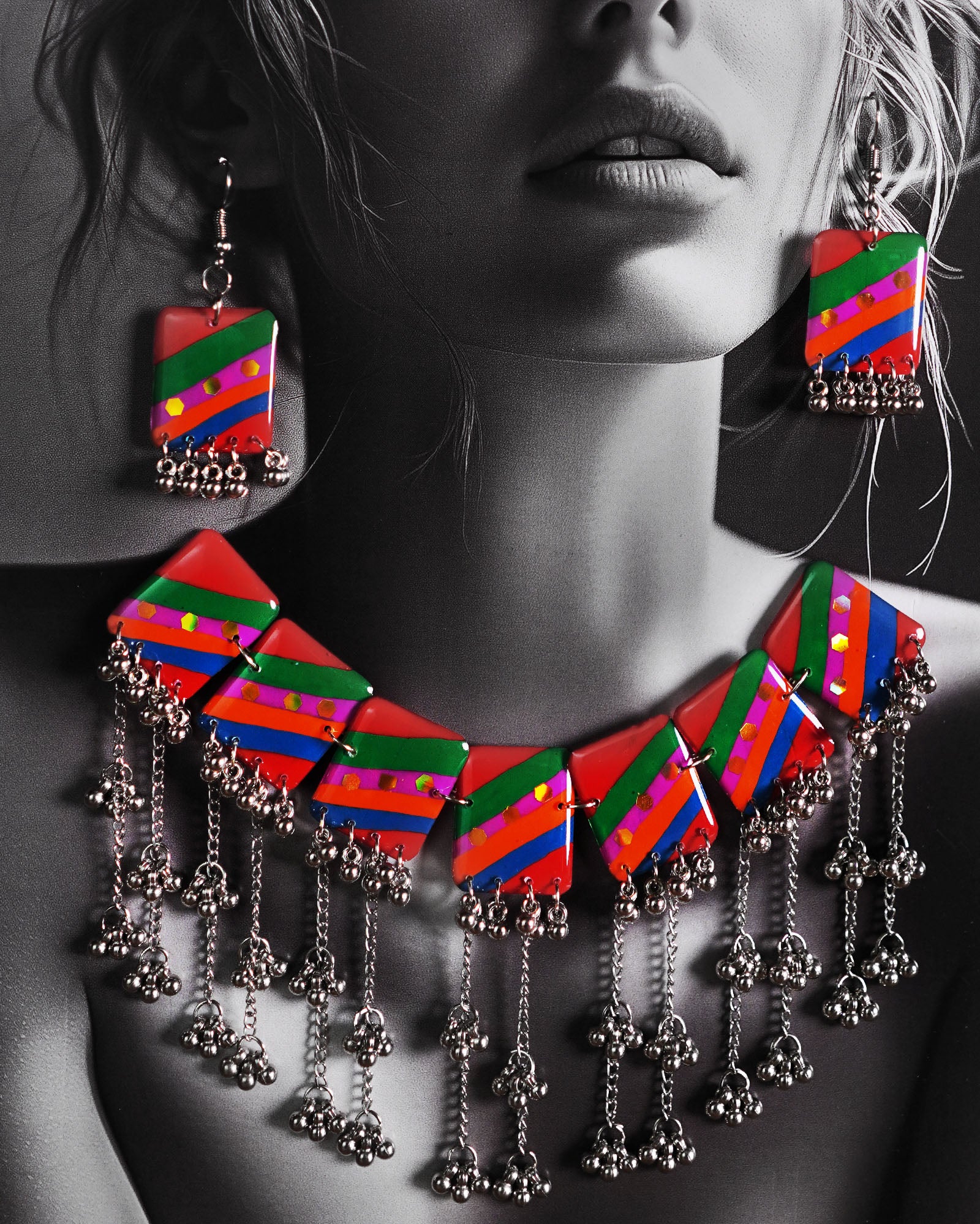 Model wearing the Gulrang multicolor resin jewelry set, showcasing a silver chain necklace with bold red, green, blue, and purple striped rectangular charms and intricate silver bead tassels, paired with matching earrings, highlighting its vibrant and artistic appeal – Muselot.