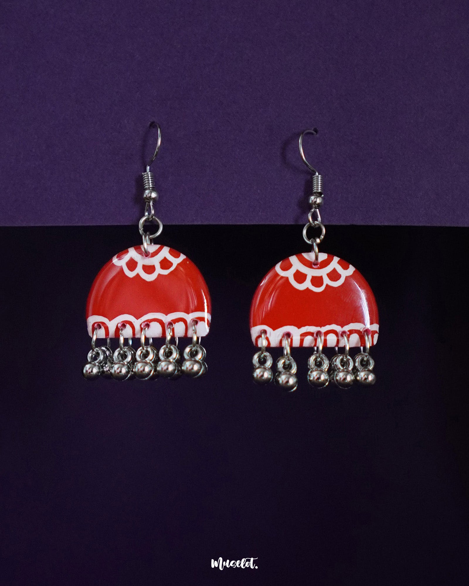 Gulzaib red hook earrings featuring delicate white flowers, beautifully highlighted against a contrasting backdrop, showcasing a fusion of vibrant red and soft floral details — Muselot.
