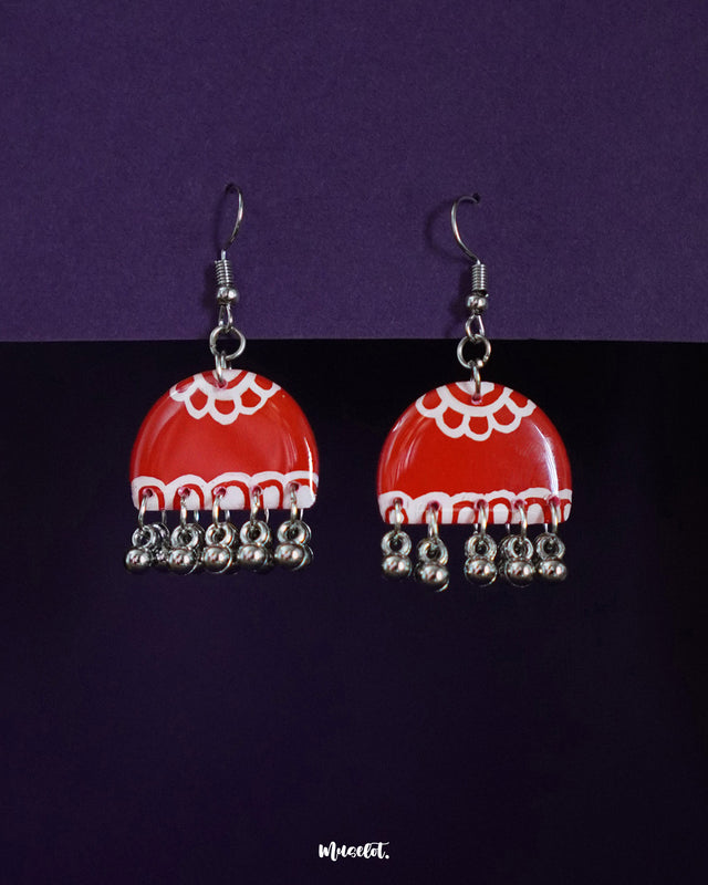 Gulzaib red hook earrings featuring delicate white flowers, beautifully highlighted against a contrasting backdrop, showcasing a fusion of vibrant red and soft floral details — Muselot.