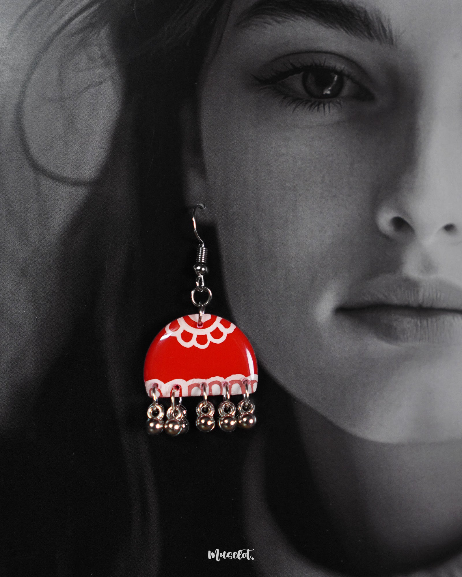 Gulzaib red hook earrings with intricate white floral accents, worn by a model, capturing the perfect blend of bold red and delicate white flowers for a charming and vibrant look — Muselot.