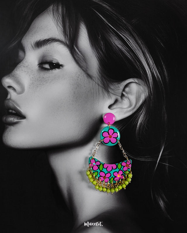 A woman wearing handmade chandbali earrings featuring intricate floral motifs and vibrant beads, showcasing the detailed craftsmanship and festive elegance of this colorful accessory — Muselot.
