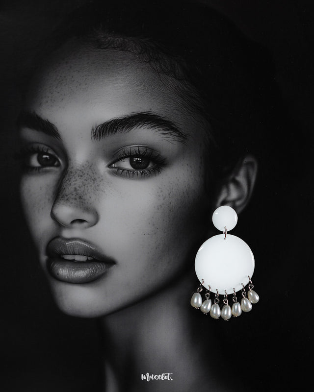 A woman wearing the handmade Noor stud drop earrings, featuring white circular studs with hanging pearl drops, showcasing the timeless grace and subtle charm of artisan-crafted elegance — Muselot.