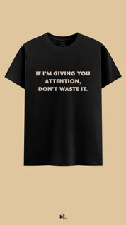 Black graphic t-shirt showcasing the “If I’m Giving You Attention, Don’t Waste It.” statement, highlighting a bold, high-value vibe against a clean, minimal beige background – Muselot