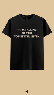 Black graphic t-shirt showcasing the “If I’m Talking to You, You Better Listen.” statement, highlighting a strong, assertive vibe perfect for statement streetwear against a clean, minimal beige background – Muselot