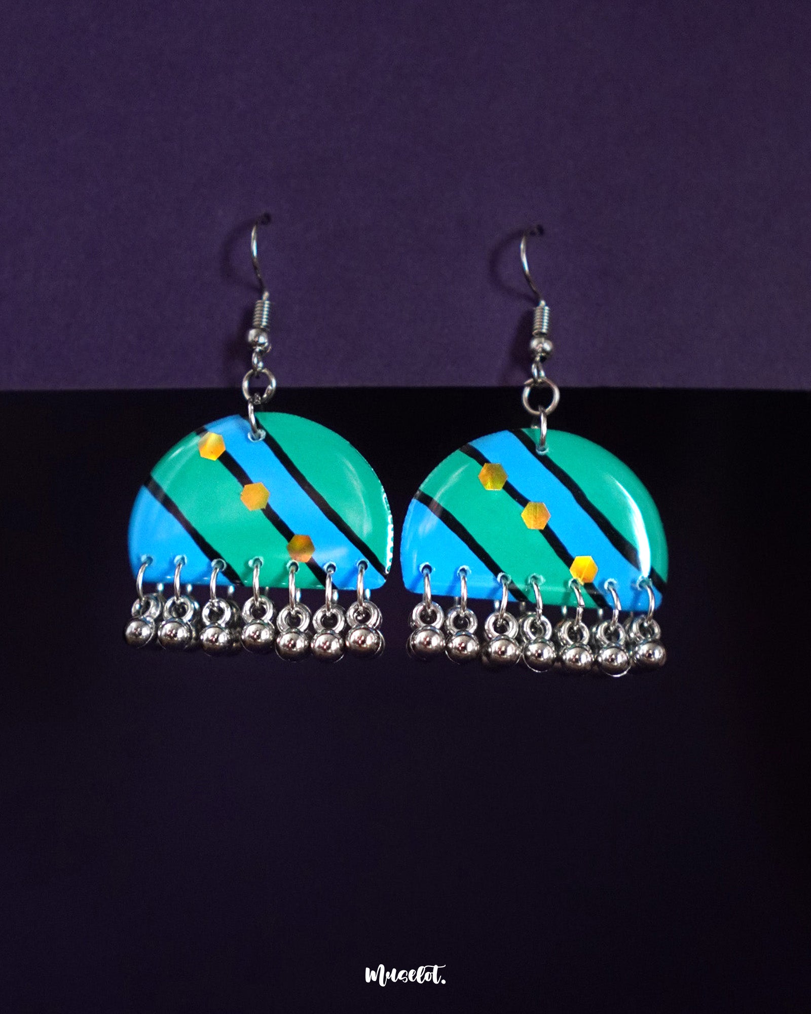 Jaltarang drop earrings featuring a vibrant hand-painted design in turquoise and blue with diagonal stripes, yellow dot accents, and silver ghungroo-style danglers—Muselot.