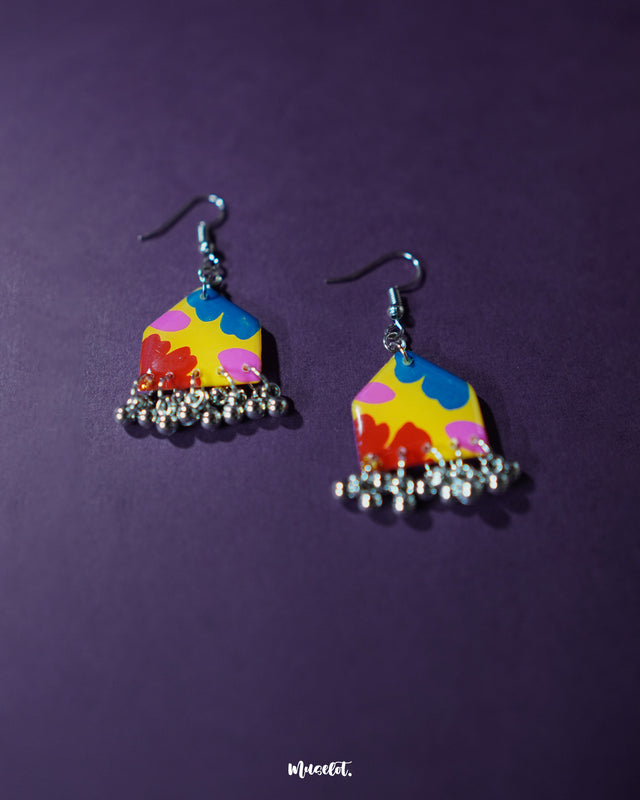 A pair of Jharokhe multicolor floral hook earrings displayed front-facing, showcasing their hand-painted floral design in vivid red, yellow, and blue tones, accented with tiny silver ghungroos — Muselot