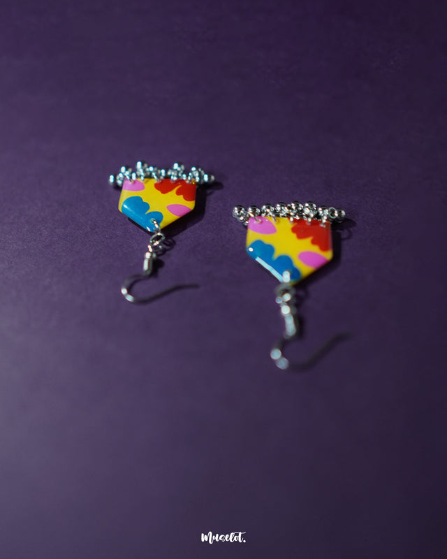 Jharokhe multicolor floral hook earrings laid on a soft purple background, showcasing the detailed hand-painted petals and tiny ghungroos for a vibrant boho charm — Muselot.
