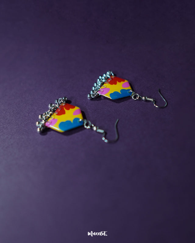 Jharokhe multicolor floral hook earrings displayed at an angle, highlighting the layered floral motifs in vivid hues and the intricate ghungroo accents that add movement and festive flair — Muselot.