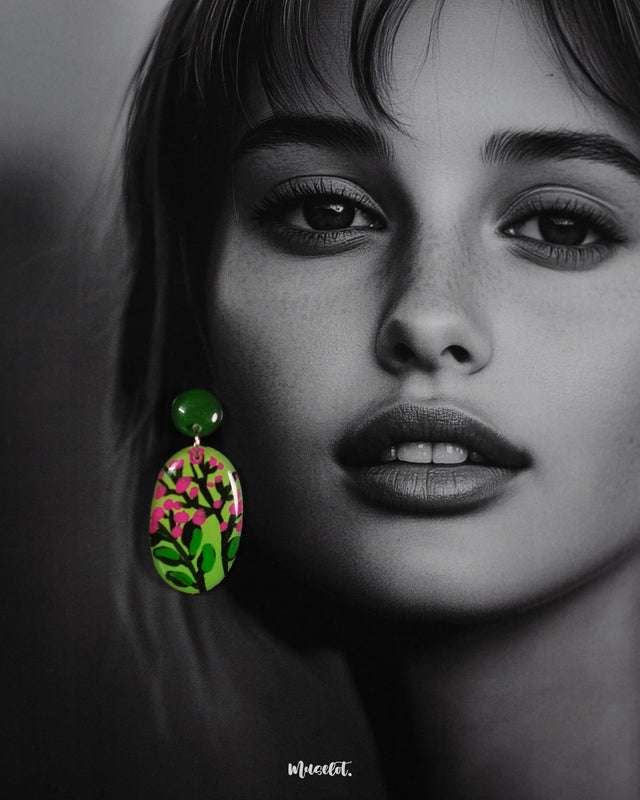 A close-up shot of a woman wearing the Kalibaan handmade drop earrings, highlighting the vibrant green and pink floral detailing. The fine hand-painted finish and lightweight design are clearly showcased, emphasizing both artistic elegance and everyday comfort — Muselot