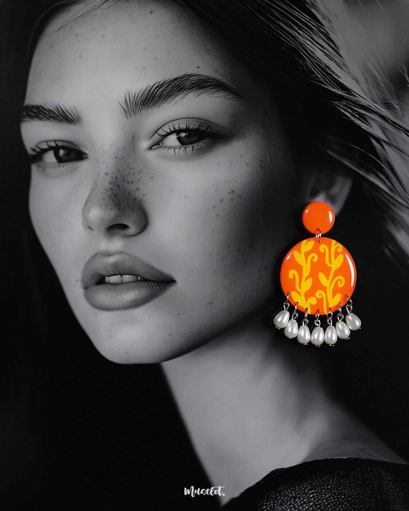 A woman showcases the Kesarbaan pearl drop earrings with effortless elegance—the bold orange-yellow design brings a burst of festive color, while the delicate white pearls add a timeless touch to her ethnic ensemble – Muselot.