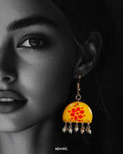 Close-up shot of a model wearing Kesarika floral earrings, adorned with intricate floral detailing and warm earthy tones that enhance the overall elegance with a touch of ethnic grace — Muselot.