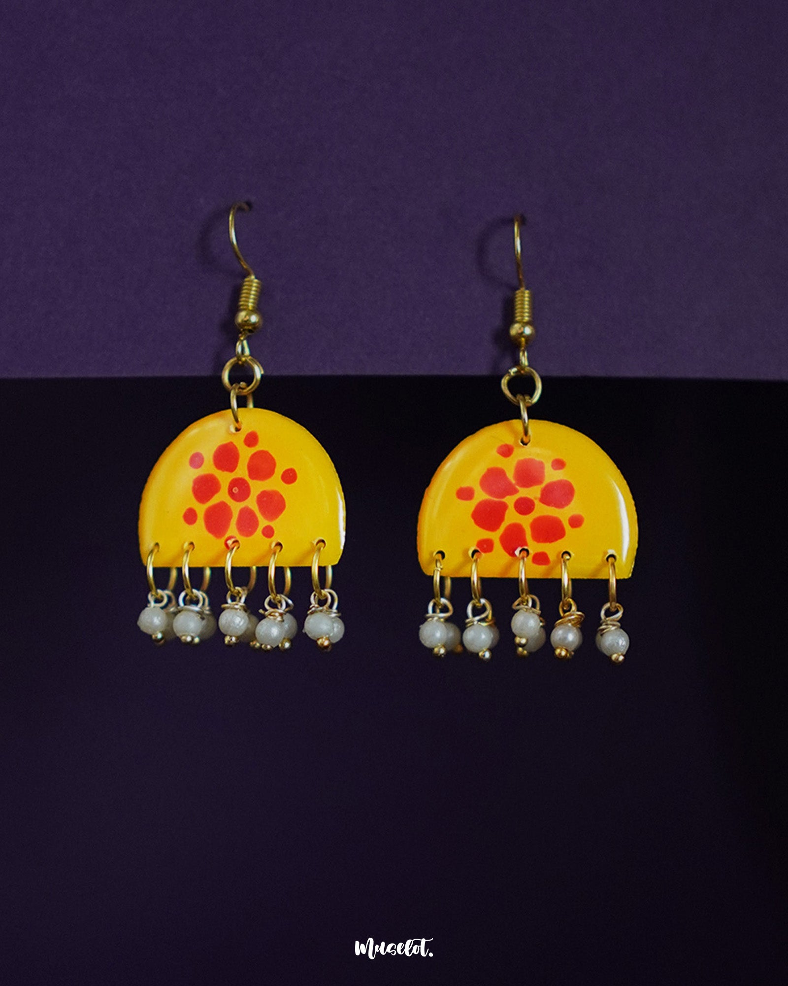 Kesarika floral earrings, set against a soft backdrop, featuring delicate floral patterns and warm tones that bring out a graceful blend of traditional charm and contemporary elegance — Muselot.