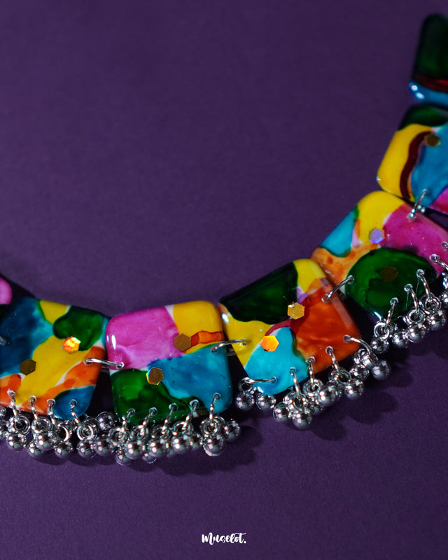 A close-up view of the Kohsar colorful necklace placed on a deep purple background, highlighting the vivid mix of multicolored beads, intricate detailing, and artisanal charm of the necklace— Muselot.