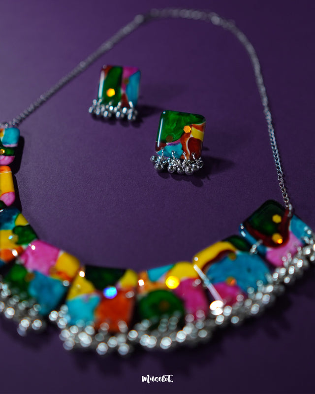 Kohsar colorful jewelry set displayed with layered beaded strands and oxidized metallic charms, arranged on a purple backdrop that accentuates its vibrant, eclectic bohemian style — Muselot