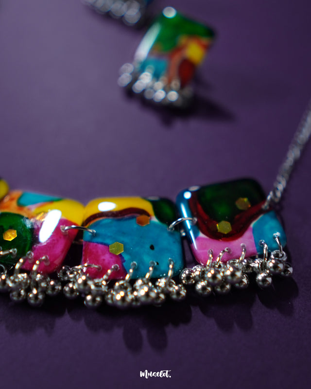 A close-up of the Kohsar colorful jewelry set highlighting the intricate detailing of its multicolor beads and antique-finish metal accents, laid on a deep purple background to enhance its vibrant boho charm — Muselot