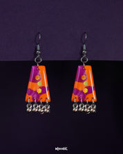 Laalsavera drop earrings against a bold purple background, highlighting their rich red tones and artistic curves that bring a dramatic, statement-making charm – Muselot